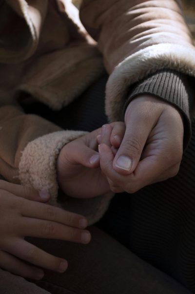 A soothing image depicting an adult and child holding hands in a gesture of warmth and affection.
